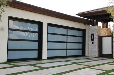 Two full-view garage doors, one single and one double, with black frames and white laminated glass on a white stucco house