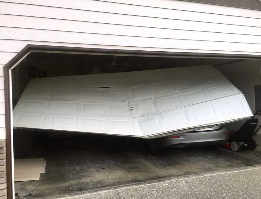 Before: a white steel garage door folded in its opening and off its track, above a parked car